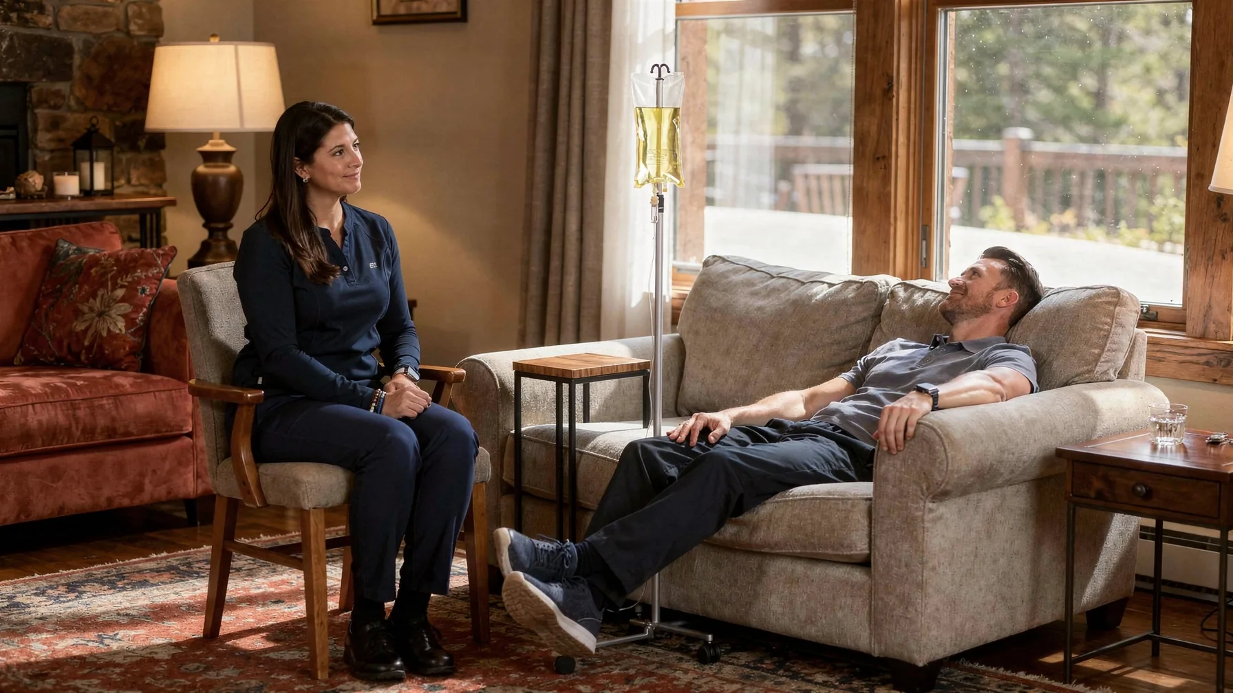 A client resting on a sofa with an IV running while the nurse sits nearby for the whole visit